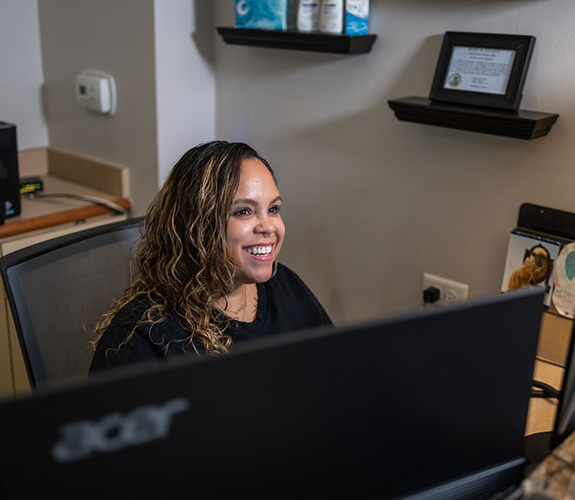 Dental team member at the front desk smiling at a patient