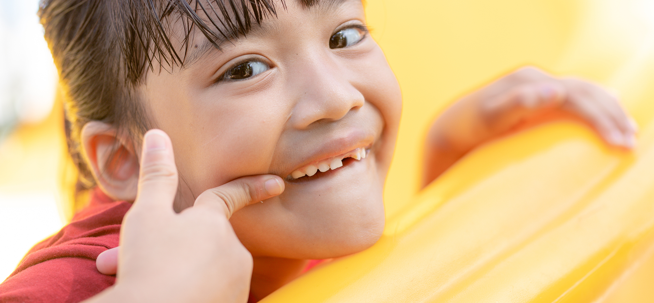 Young girl pointing to her smile