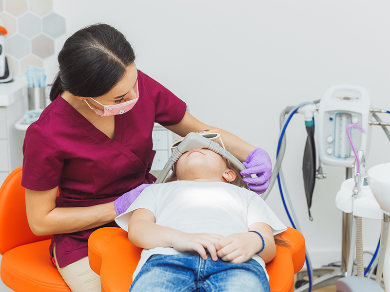 Child in the dental chair wearing a nitrous oxide mask on their nose