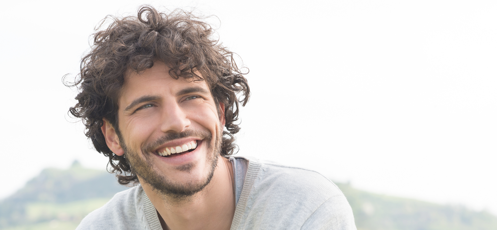 Young man smiling outdoors after cosmetic dentistry in Lincoln Park