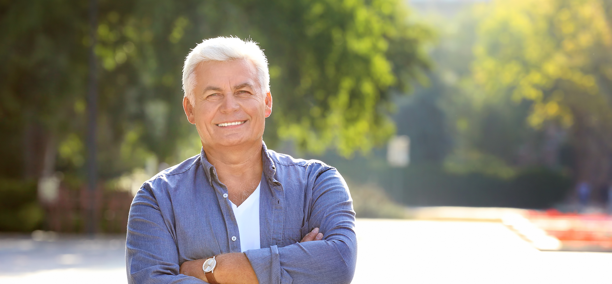 Older man smiling outdoors after gum disease treatment in Lincoln Park