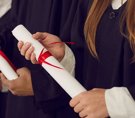 Person in graduation robes holding a diploma