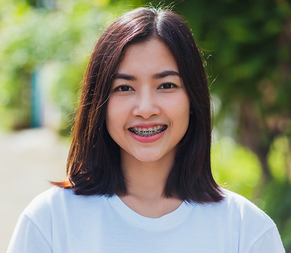 Young woman smiling with traditional braces