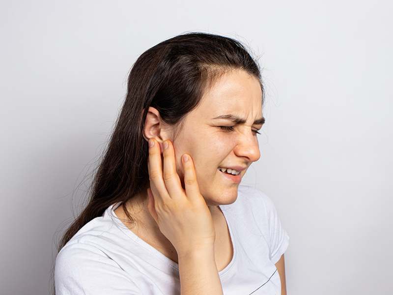 Woman holding the side of her jaw in pain