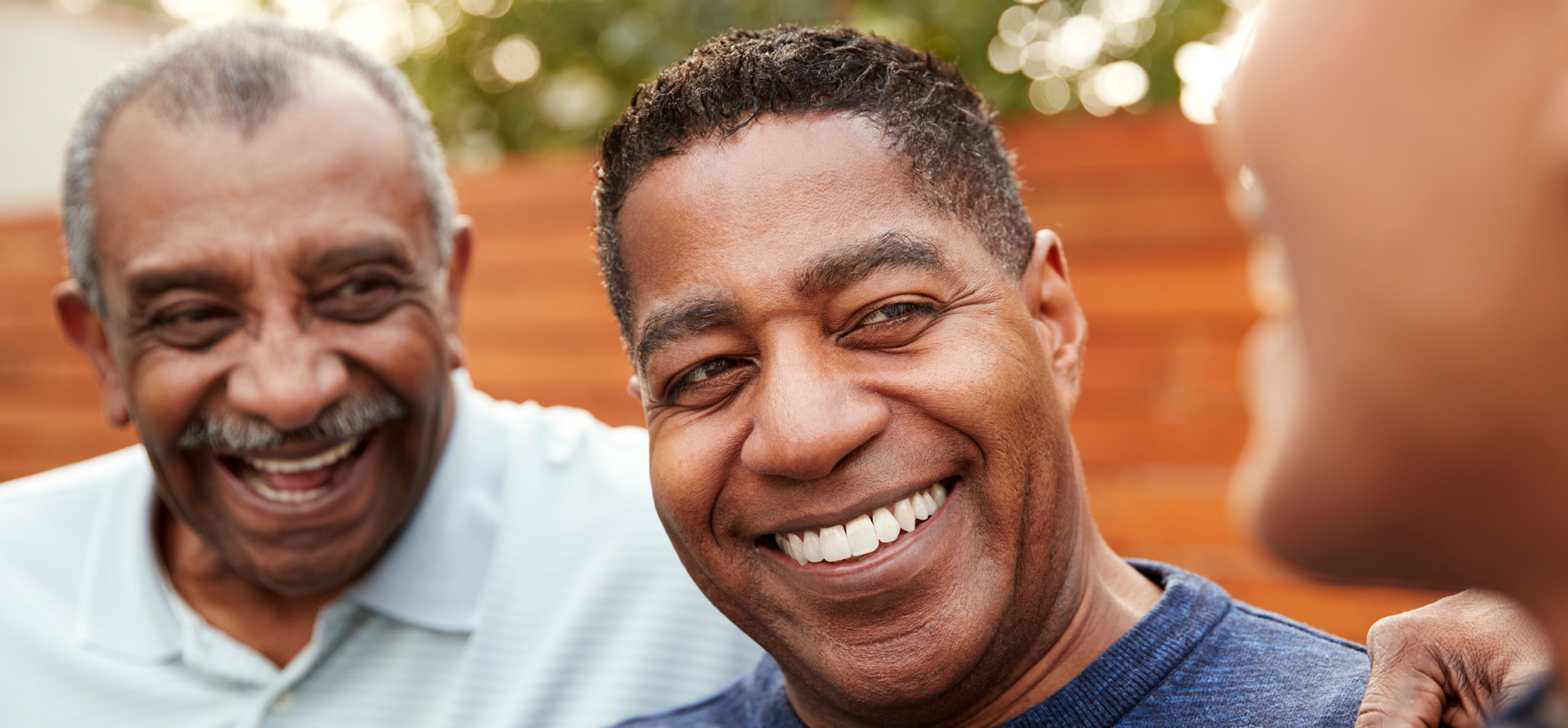 Three men laughing together outdoors