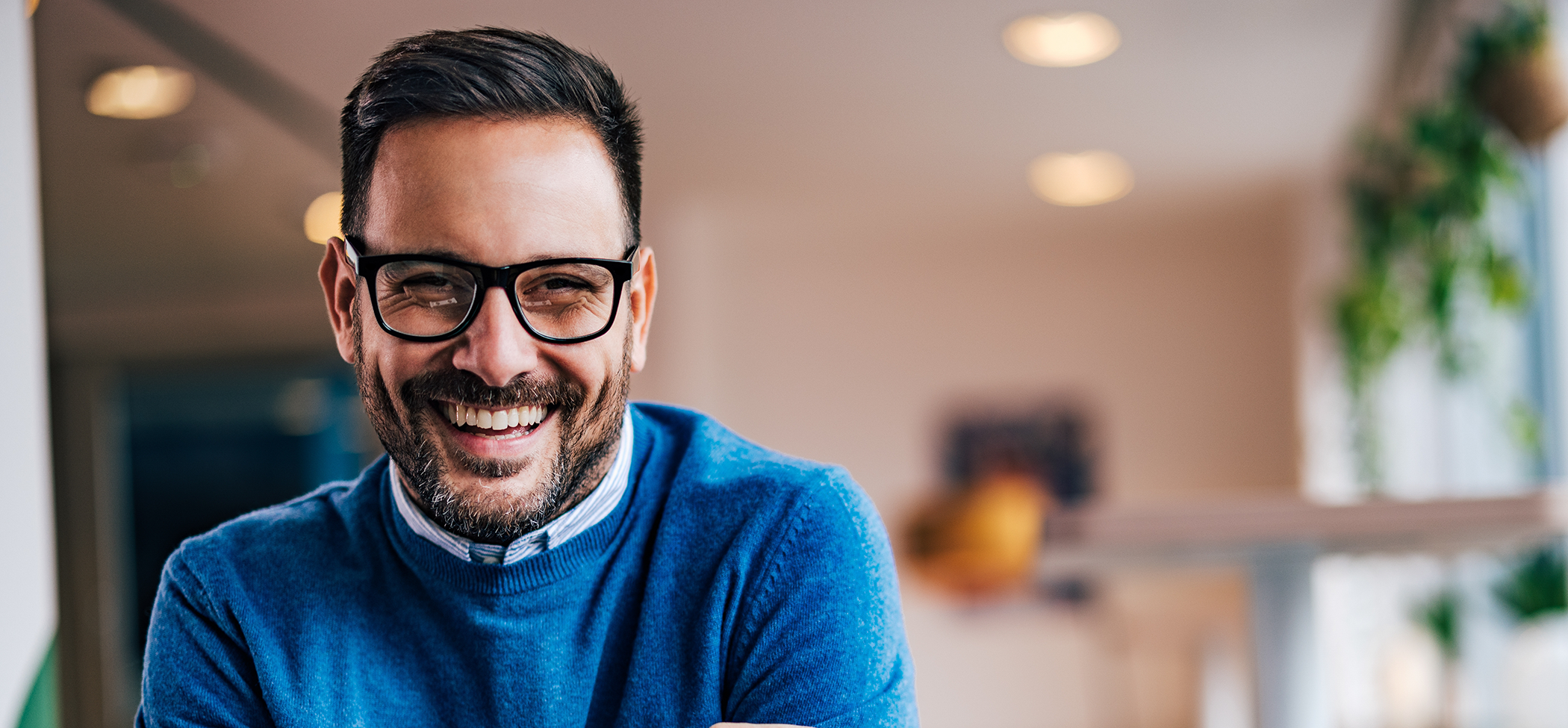 Smiling man in glasses and a blue sweater